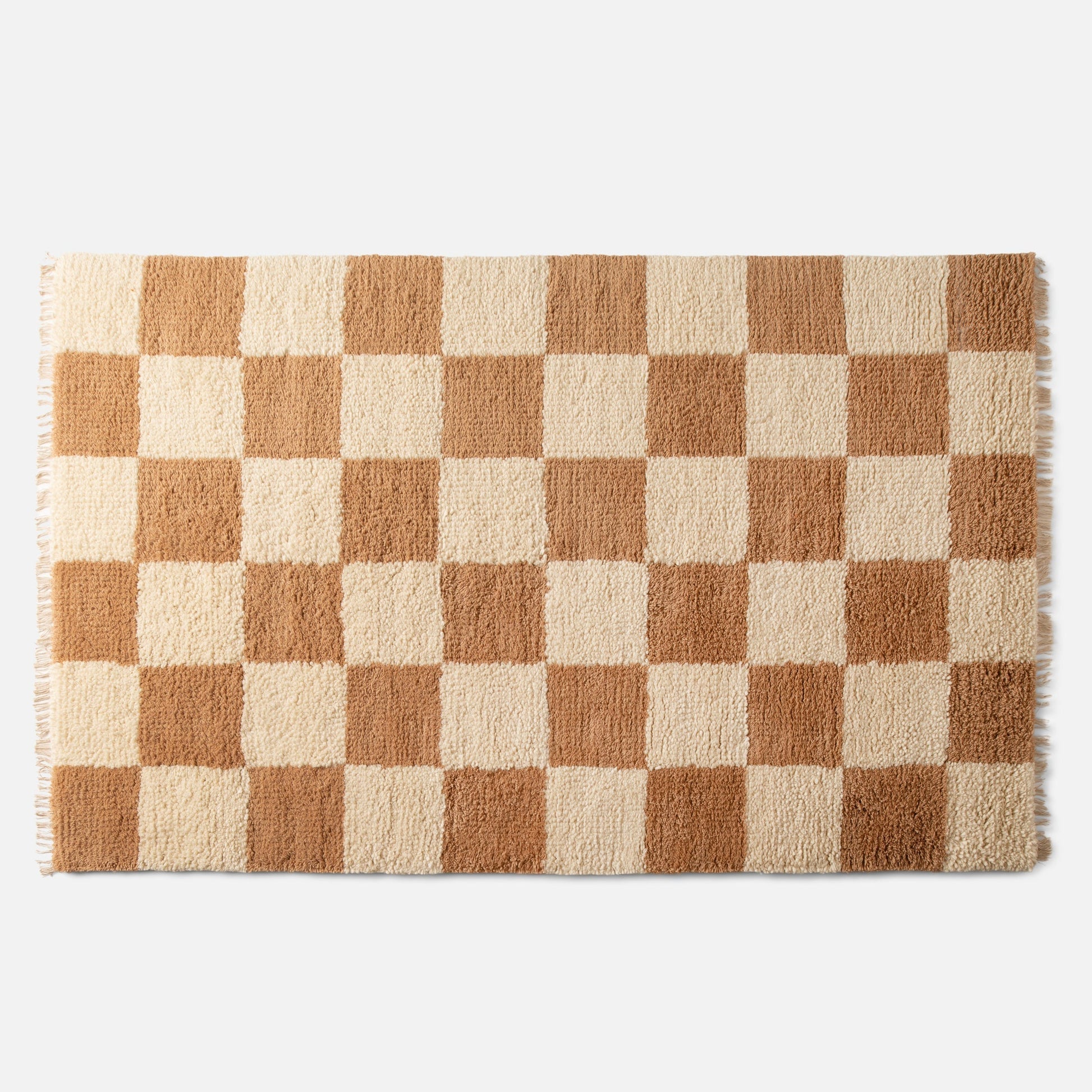 close-up top view of Jacques shag wool rug showcasing cream and tan checkerboard pattern, high-pile wool texture, and fringe on a white background