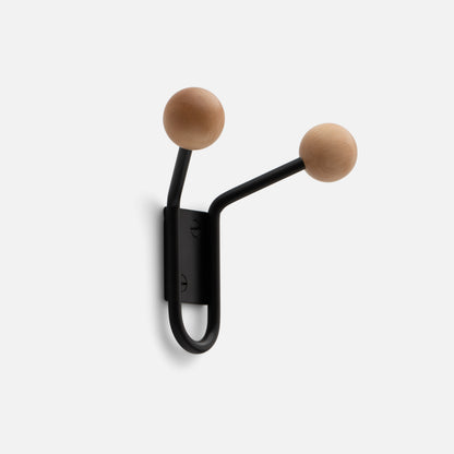 Close-up of Mollie Double Hook showcasing oak ball tips on black painted steel arms against a white background