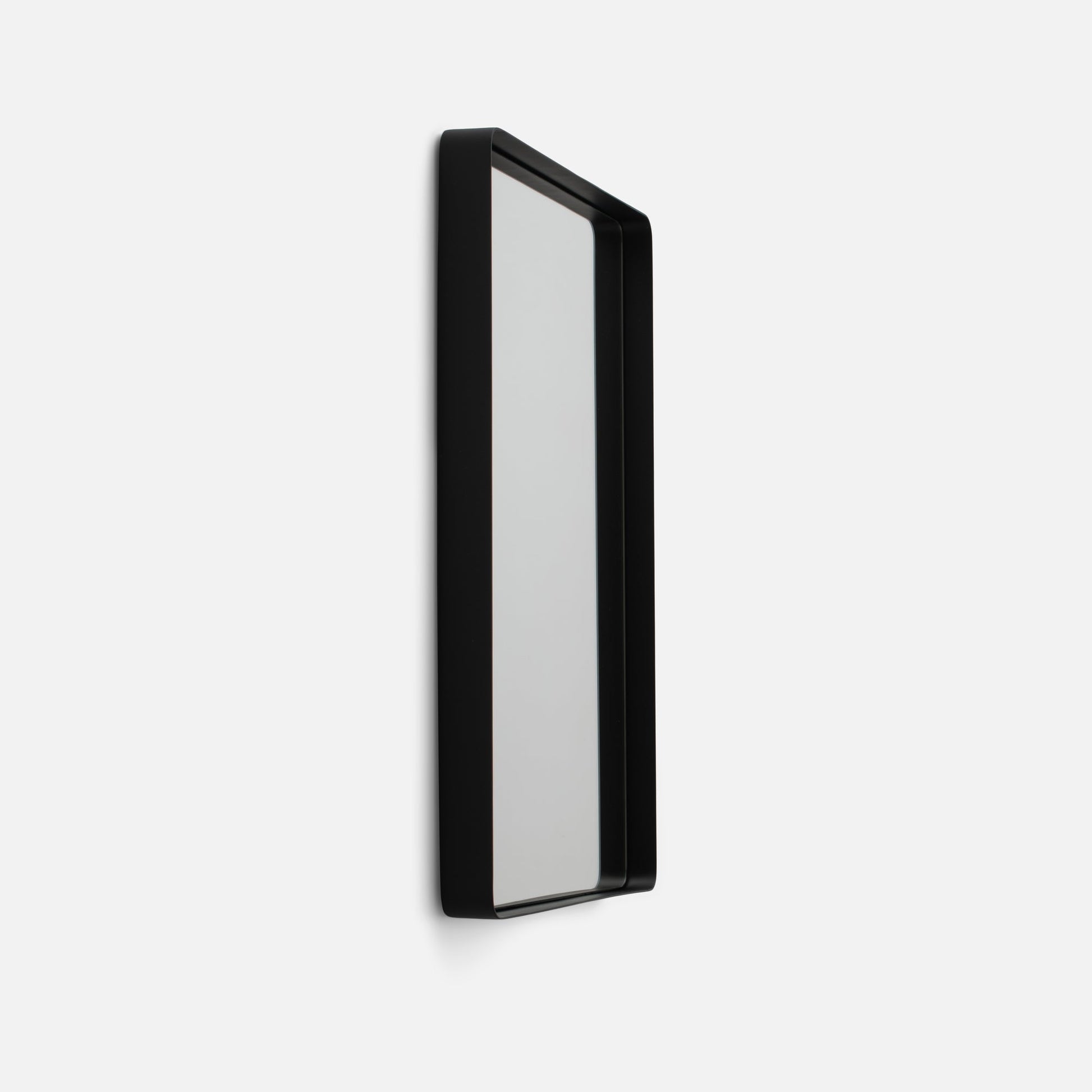 Angled side view of Leo Mirror showcasing black rounded metal frame and slim profile on white background