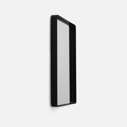 Angled side view of Leo Mirror showcasing black rounded metal frame and slim profile on white background
