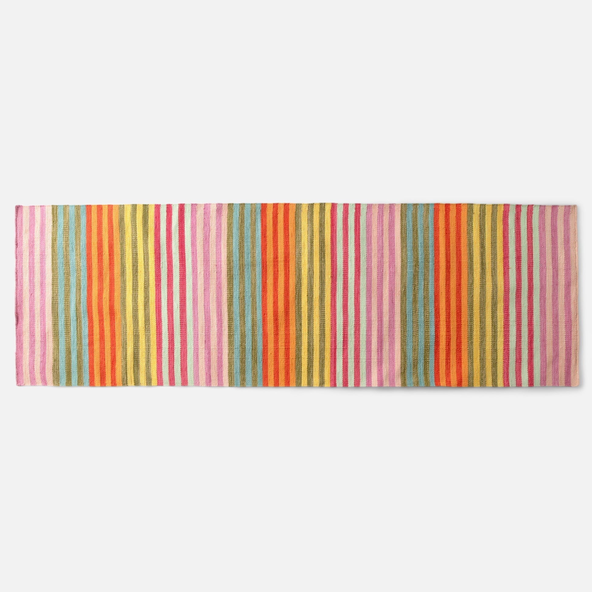 Top-down view of Lisse Performance flatweave rug showcasing bold multicolored vertical stripes on a white background