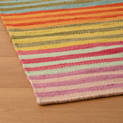 Close-up of Lisse Performance Rug showing multicolored flatweave stripes and low-profile edge on a hardwood floor