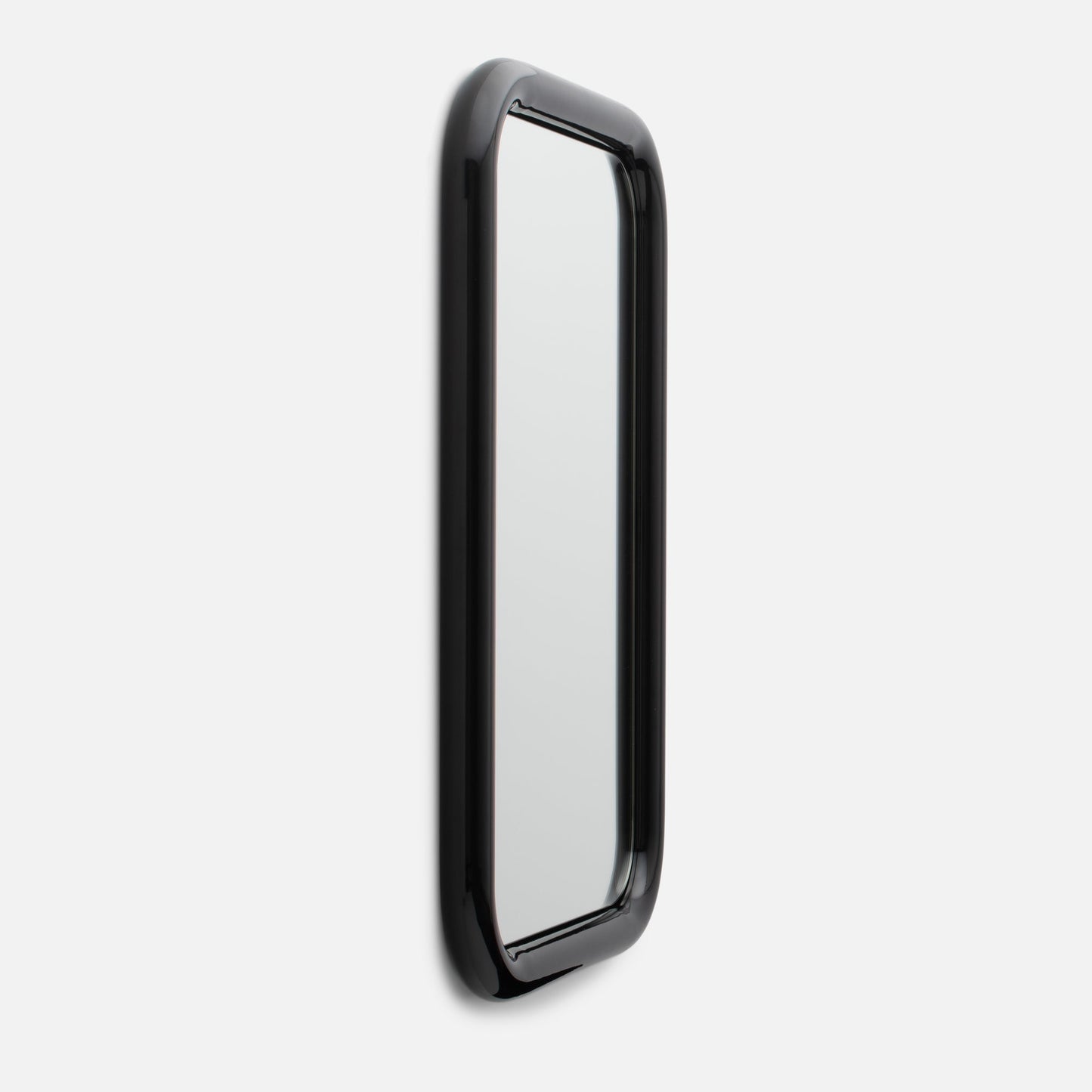 Angled close-up of Forma Mirror showing glossy black rounded frame and slim rectangular mirror on white background