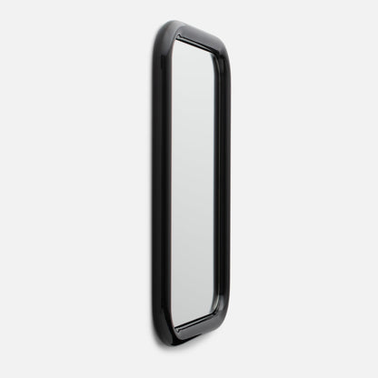 Angled close-up of Forma Mirror showing glossy black rounded frame and slim rectangular mirror on white background