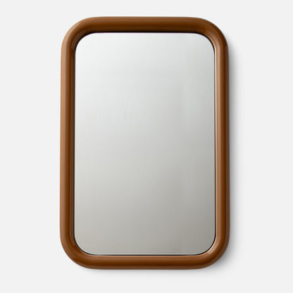 Close-up top view of Forma mirror showcasing rounded glossy brown frame on a white background