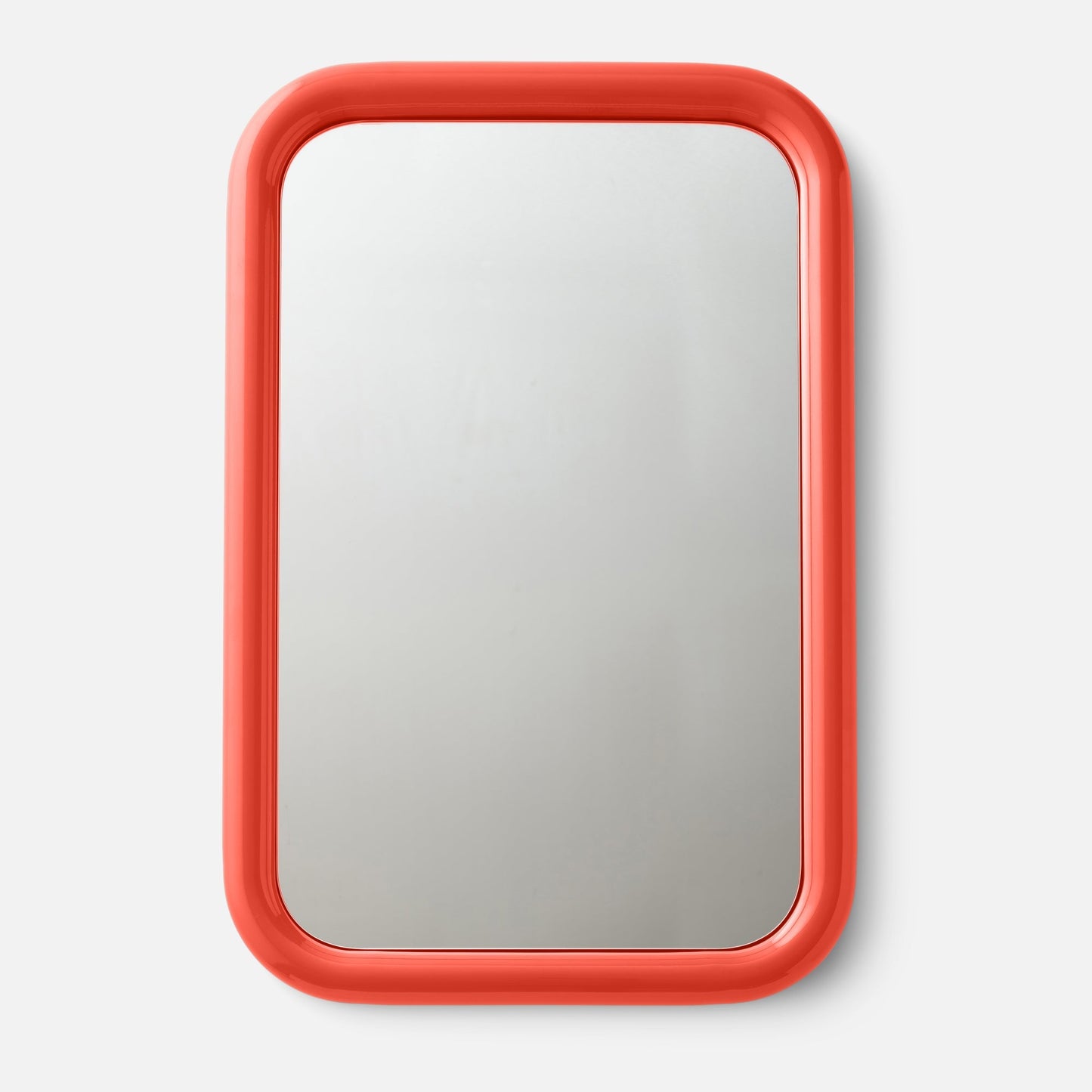 Close-up top view of Forma mirror showcasing glossy coral-red rounded frame against a white background