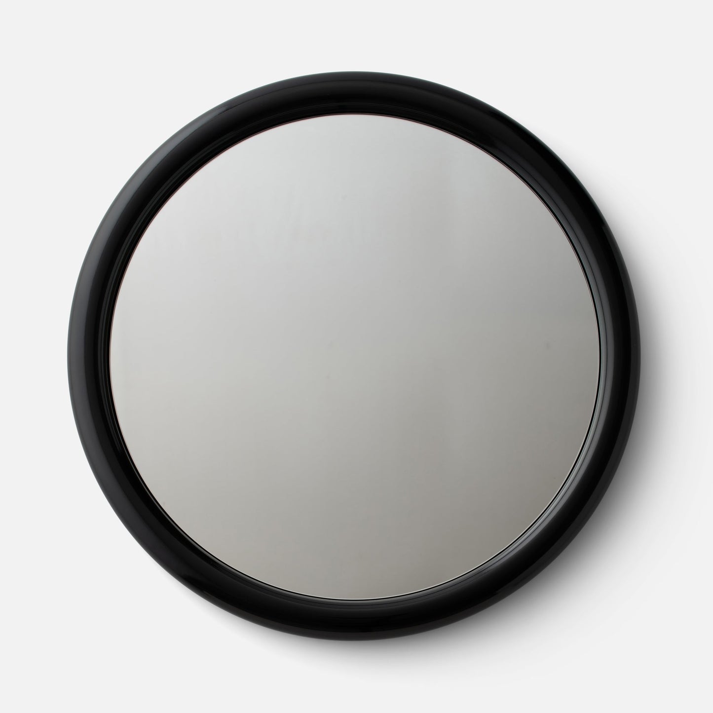 Close-up top view of Forma Mirror showcasing glossy black rounded frame on a white background