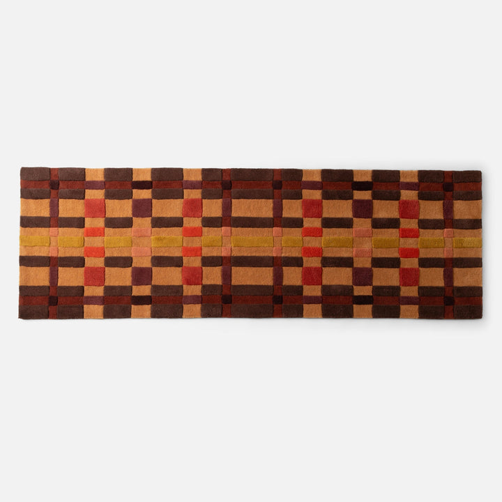 Top-down view of Campus Wool Rug showcasing recessed pile and plaid gradation in brown, rust, and mustard on white background