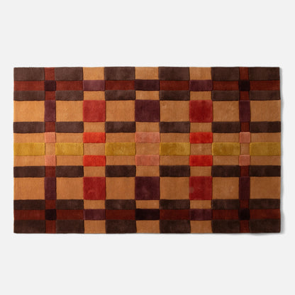 Top-down view of Campus Wool Rug showing recessed-pile plaid grid in brown, rust, mustard, and burgundy on white background