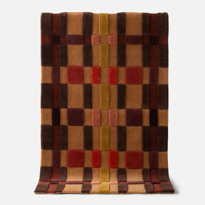 Top view of Campus Wool Rug showing recessed pile and plaid-inspired squares in warm brown, rust, and mustard on a light gray background