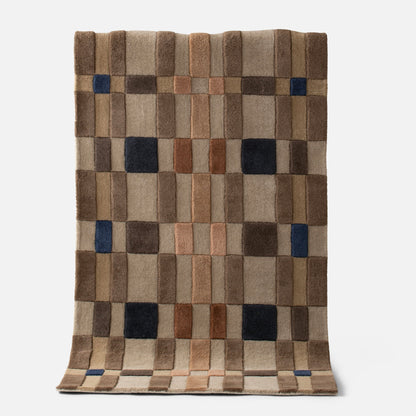 Top view of Campus Wool Rug, recessed pile and plaid-inspired brown grid with navy accent squares on white background