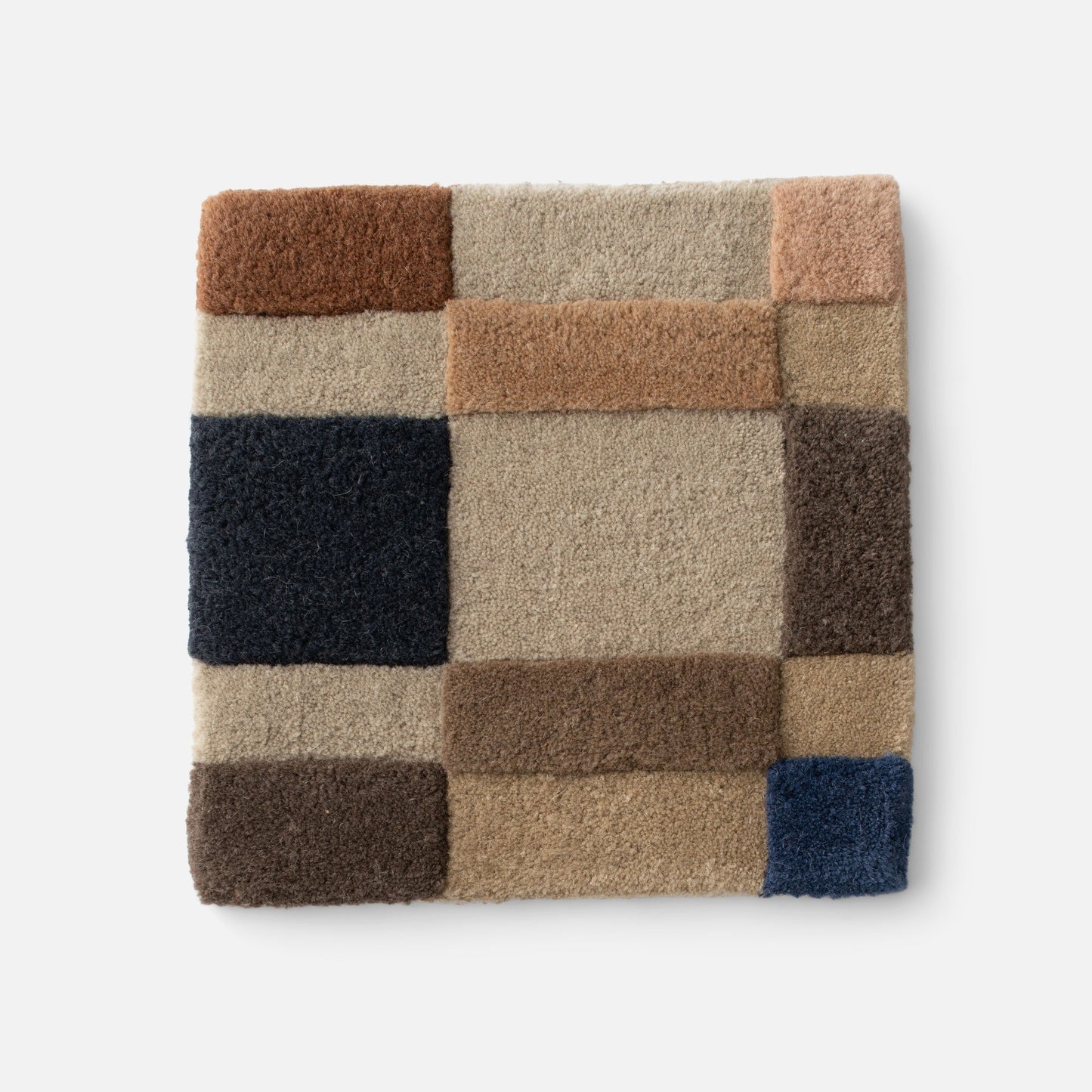 Close-up of Campus Wool Rug showing recessed-pile texture and block plaid in brown, beige, tan and navy