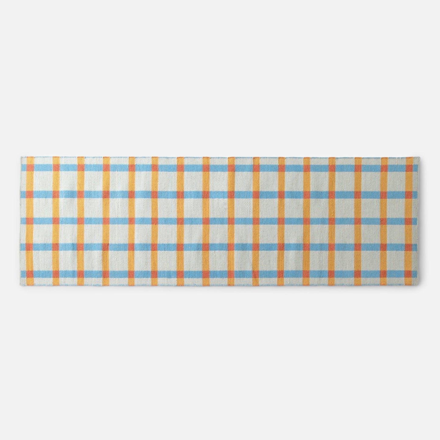 Top edge of Plaid Wool Reversible Rug showing orange and blue high-contrast plaid handwoven from natural-dyed wool on white background