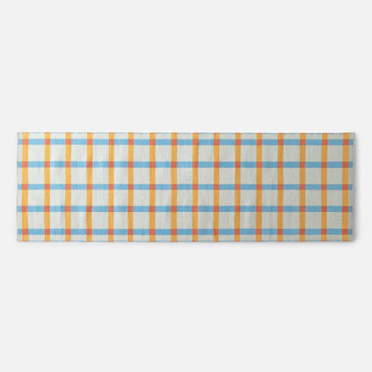 Top edge of Plaid Wool Reversible Rug showing orange and blue high-contrast plaid handwoven from natural-dyed wool on white background
