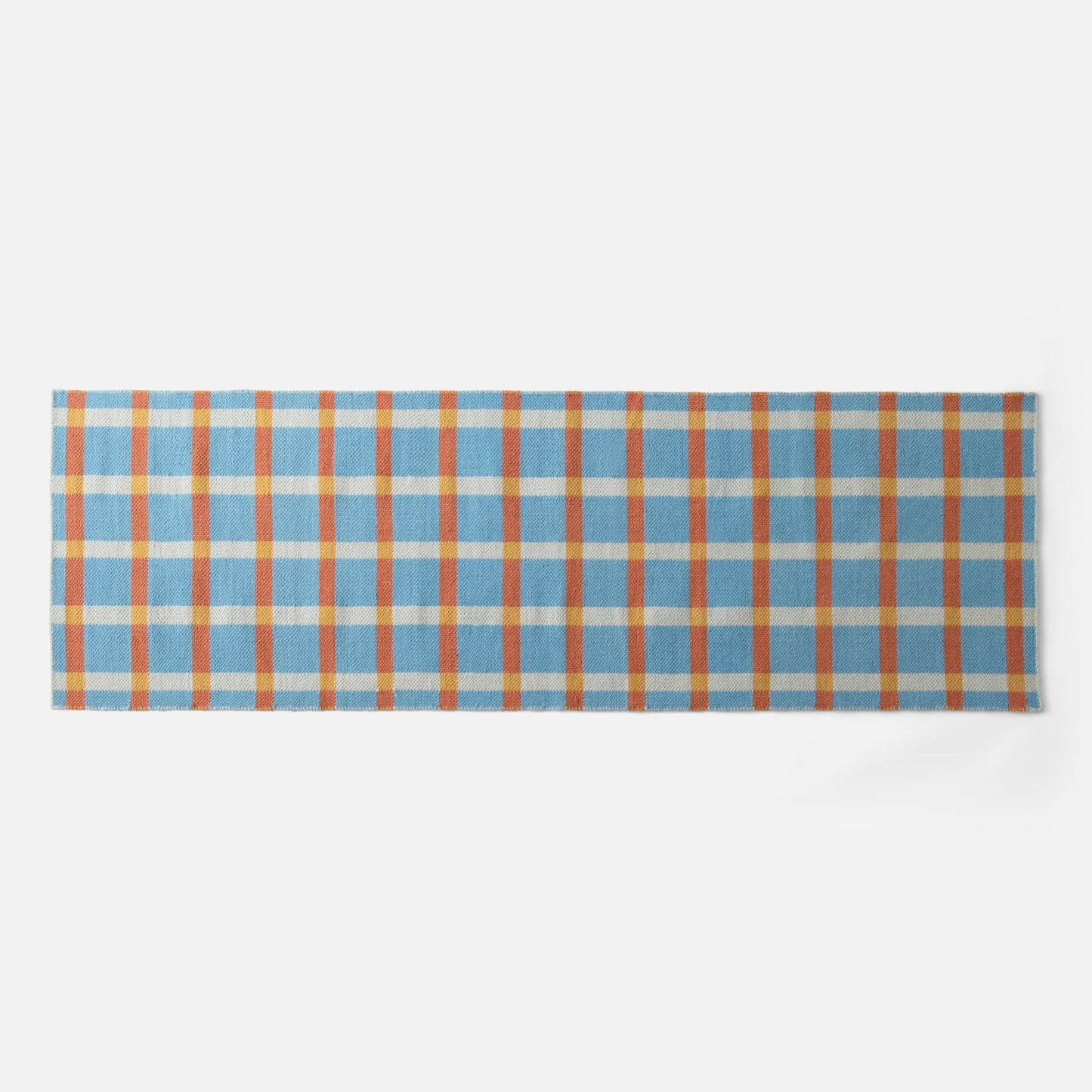 Close-up top-edge view of Plaid Wool Reversible Rug showing blue, orange and yellow plaid on white background