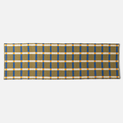 Flat lay of Plaid Wool Reversible Rug showing olive handwoven wool plaid with blue and yellow stripes on white background