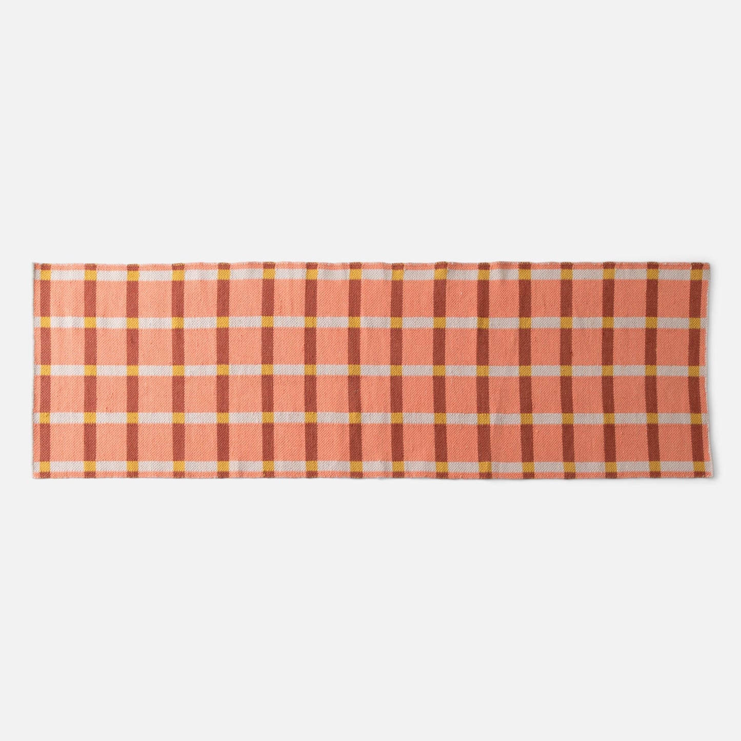 Flat-lay of Plaid Wool Reversible Rug showing peach and rust plaid with yellow and white checks on white background