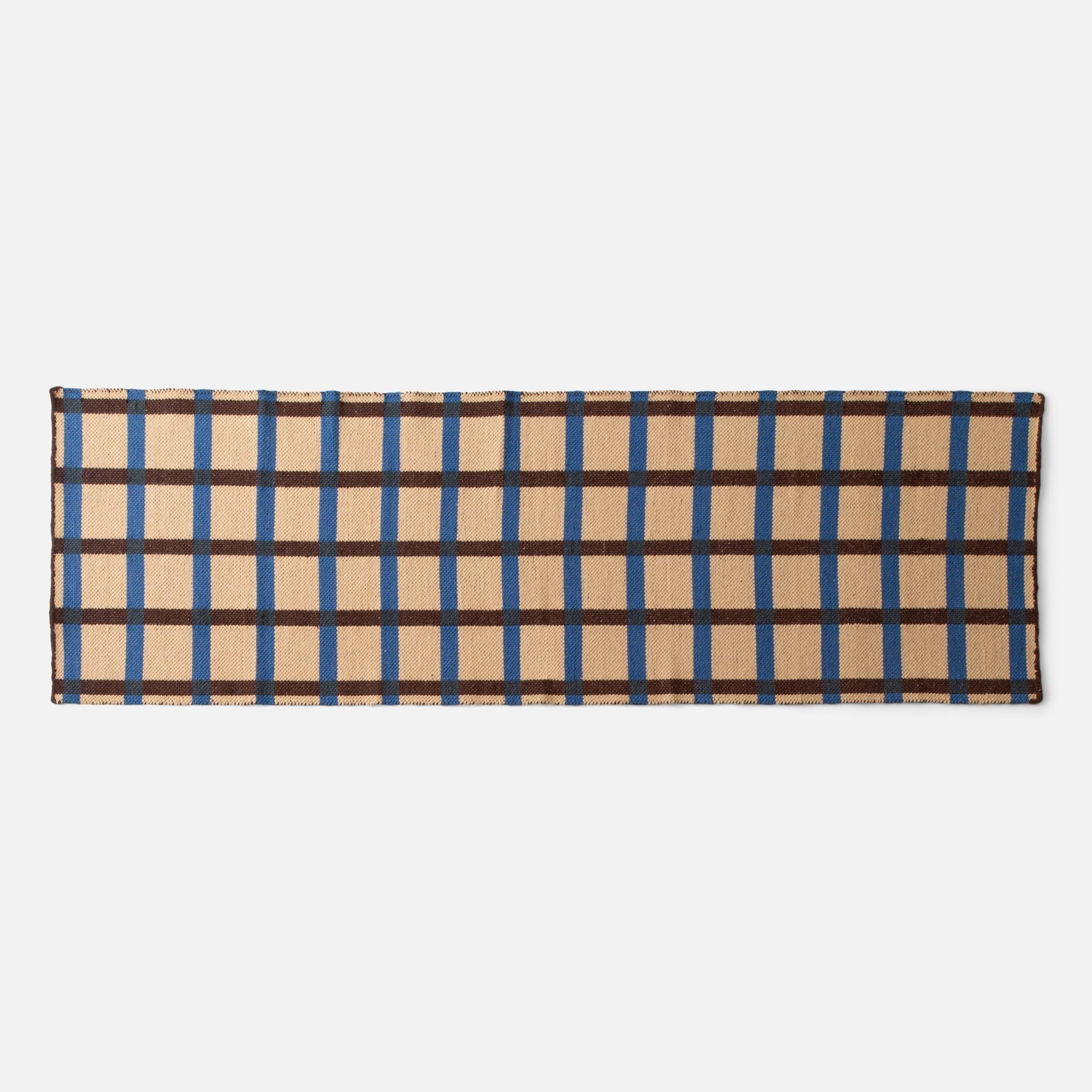 Top edge of Plaid Wool Reversible Rug showing woven beige plaid with blue and brown stripes on white background