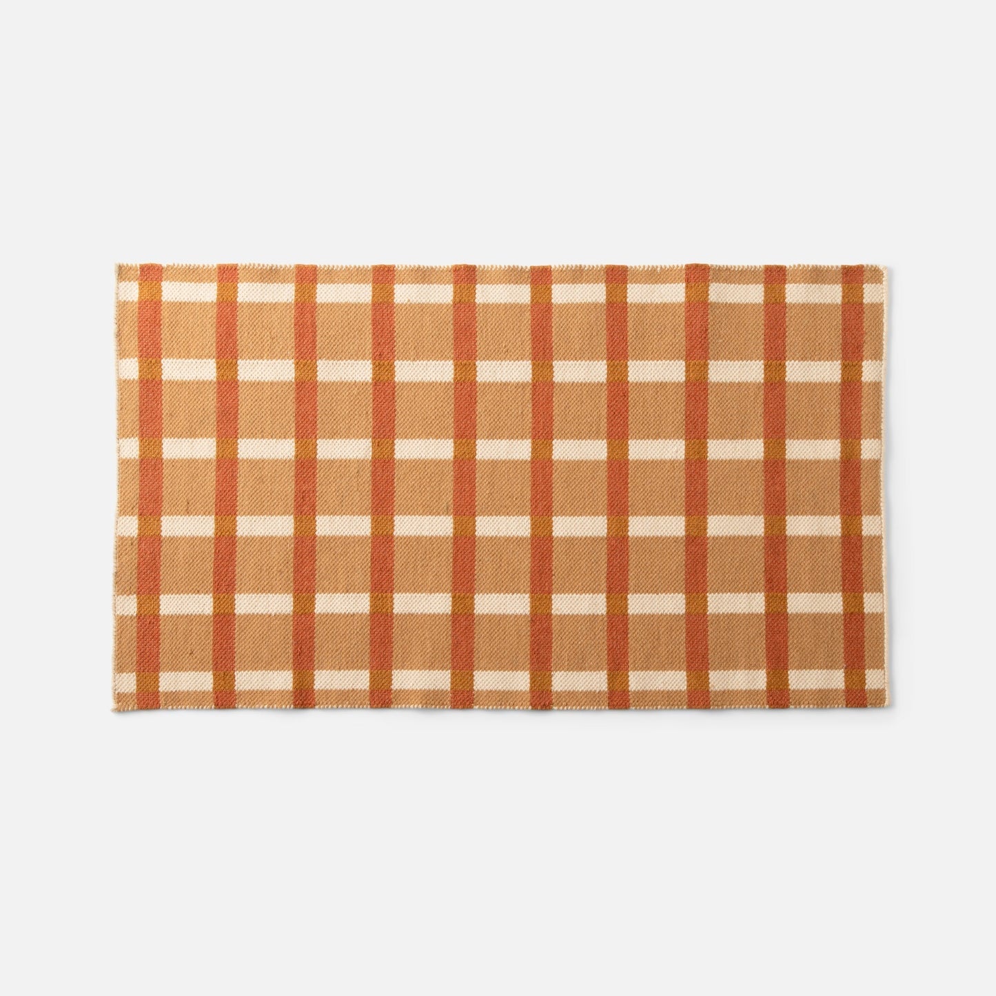 Top-down view of Plaid Wool Reversible Rug showcasing orange, tan and cream plaid and woven wool texture with gray background