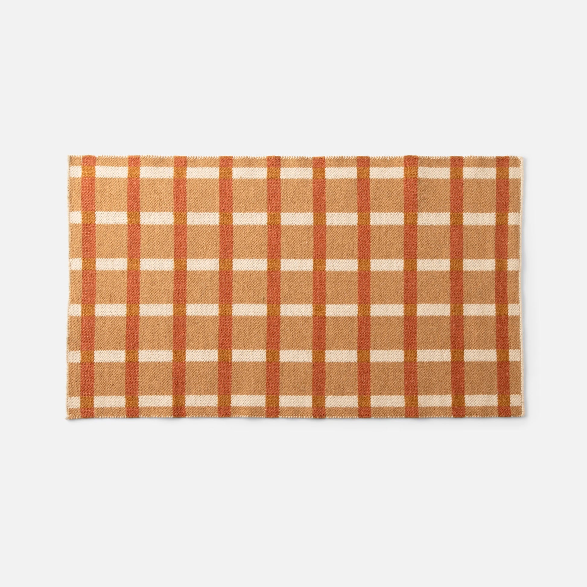 Top-down view of Plaid Wool Reversible Rug showcasing orange, tan and cream plaid and woven wool texture with gray background