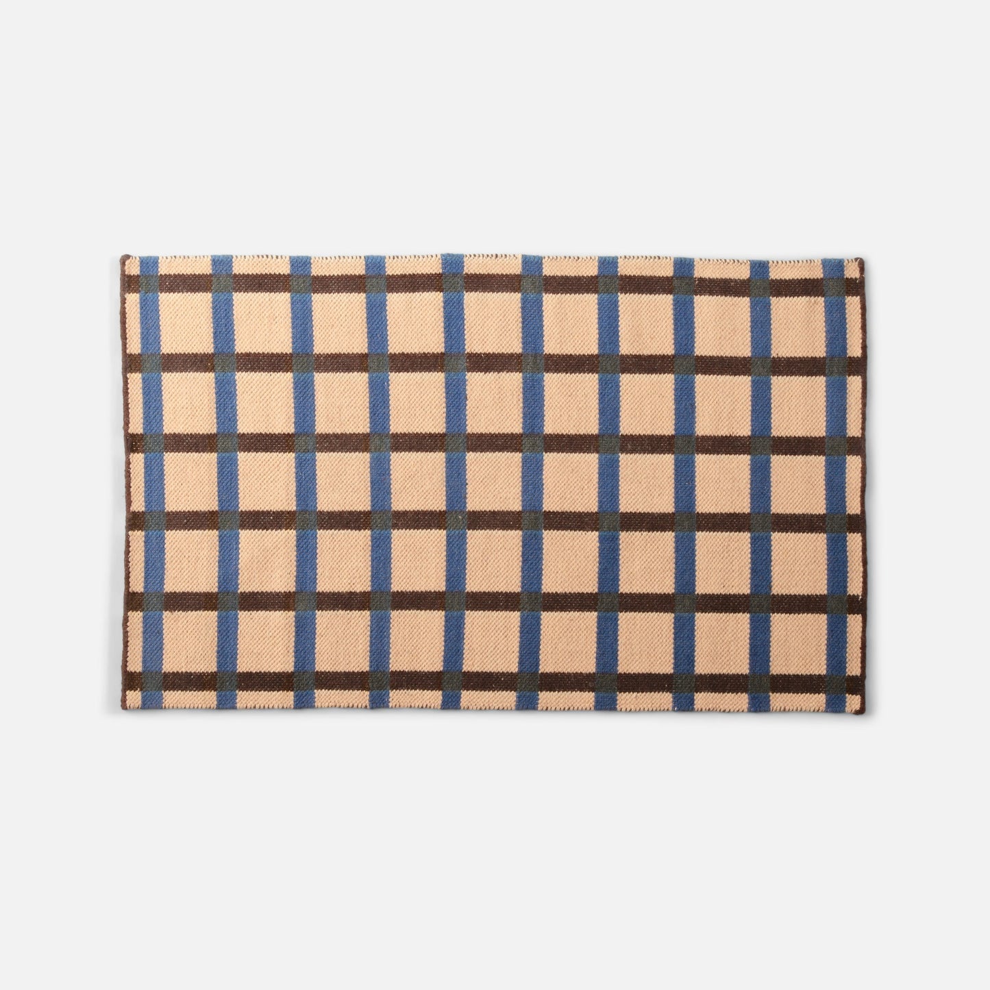 Flat-lay top edge of Plaid Wool Reversible Rug showing peach ground with blue and brown plaid pattern on white background