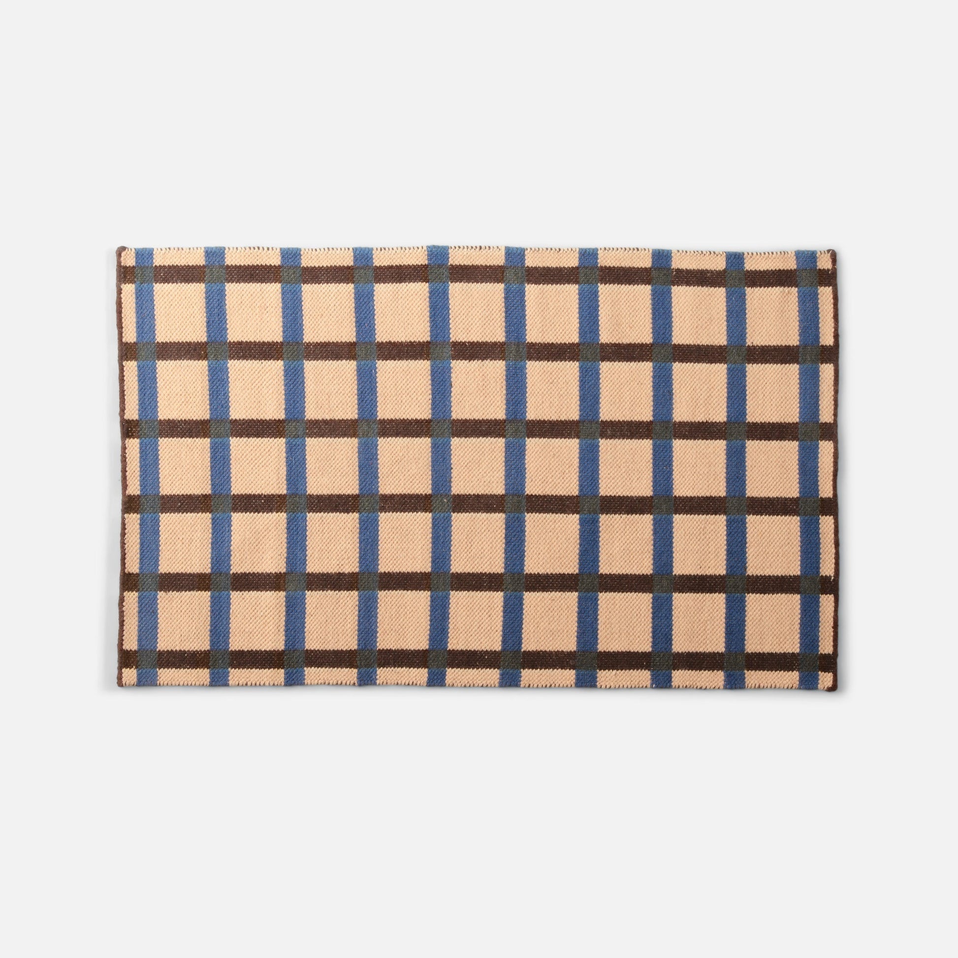 Flat-lay top edge of Plaid Wool Reversible Rug showing peach ground with blue and brown plaid pattern on white background