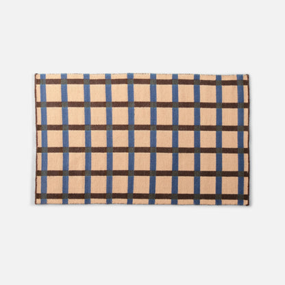 Flat-lay top edge of Plaid Wool Reversible Rug showing peach ground with blue and brown plaid pattern on white background