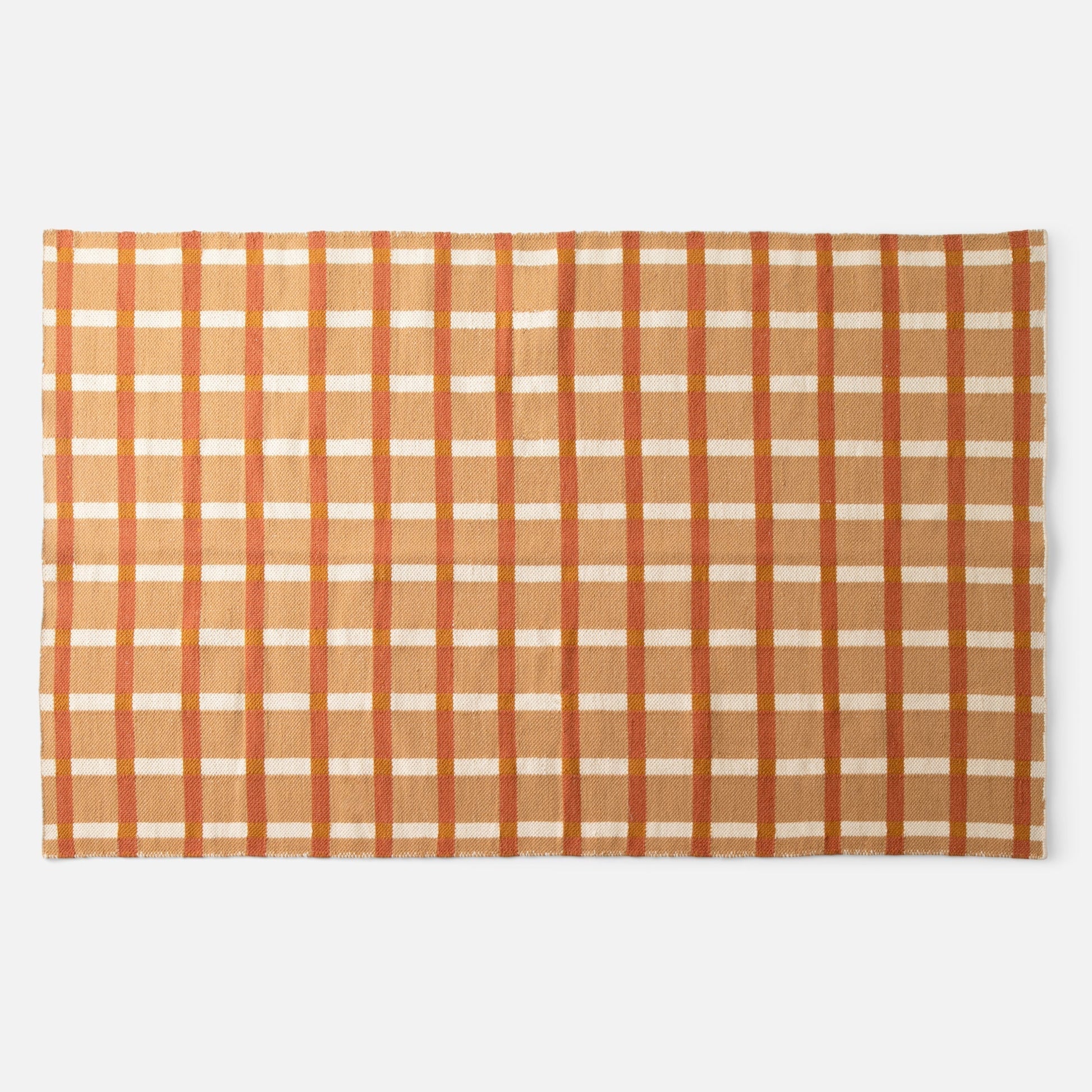 Flat lay of Plaid Wool Reversible Rug showing handwoven natural-dyed wool in orange and tan plaid on white background