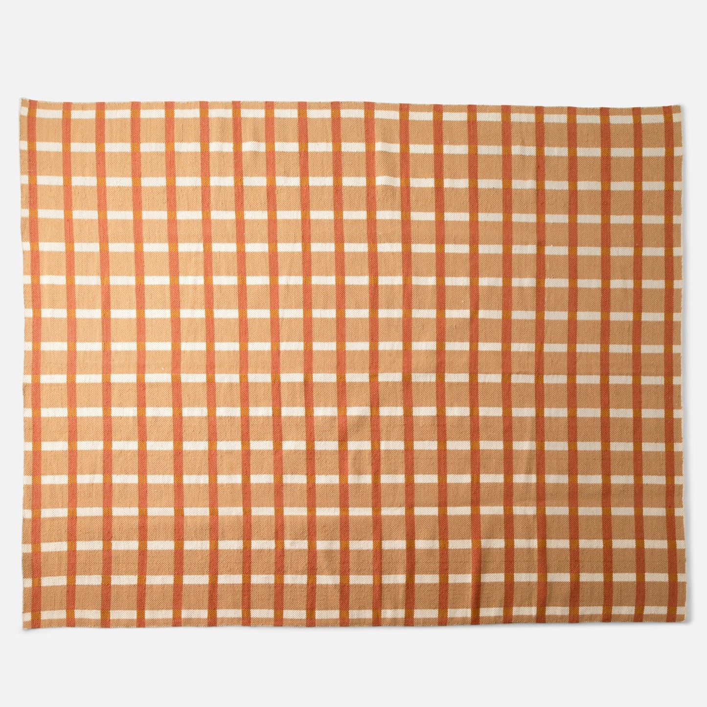 Top view of Plaid Wool Reversible Rug showing orange and tan plaid and handwoven wool texture on white background