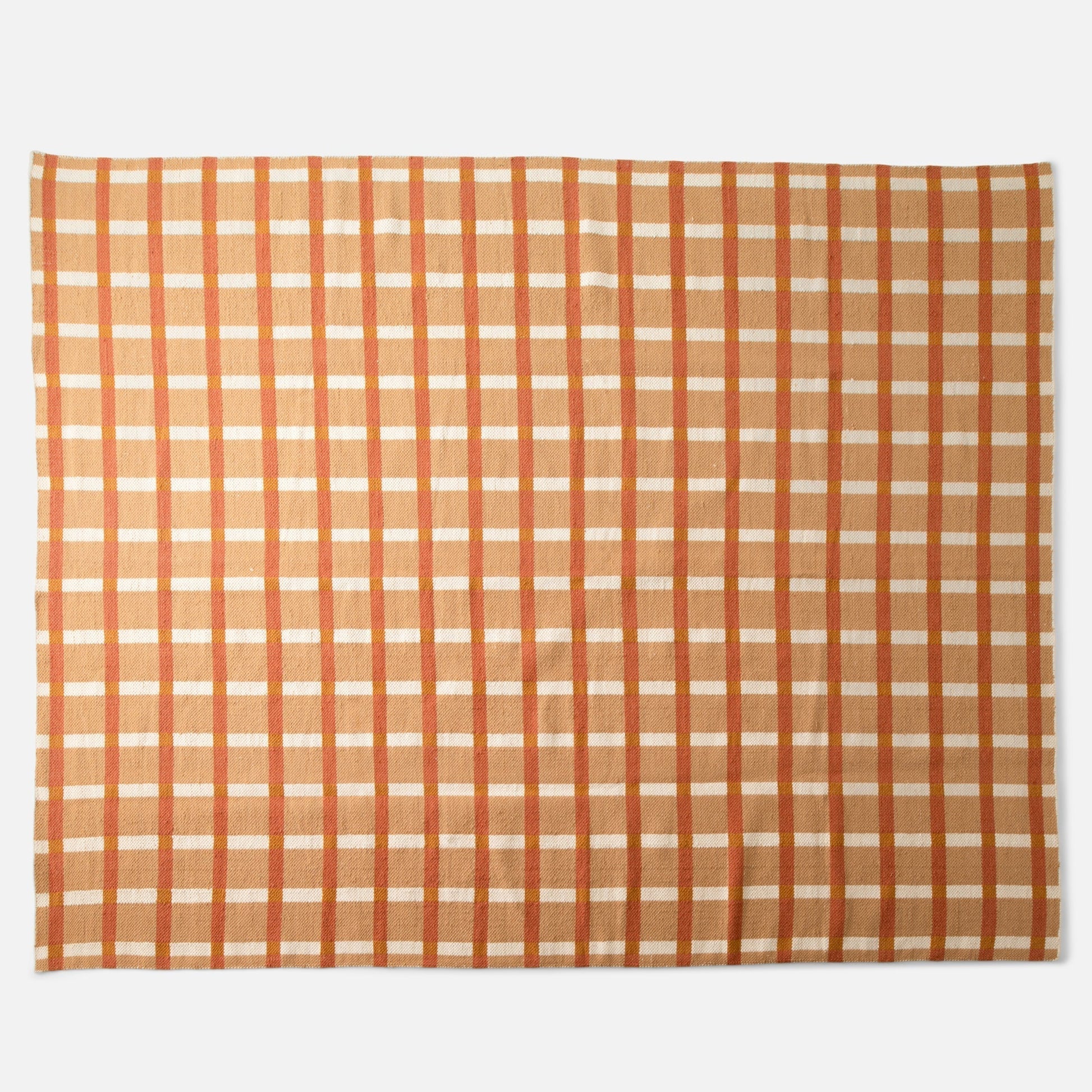 Top view of Plaid Wool Reversible Rug showing orange and tan plaid and handwoven wool texture on white background