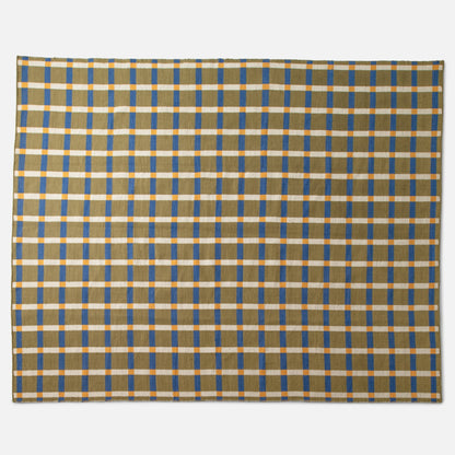 Flat lay of Plaid Wool Reversible Rug (olive) showcasing bold blue and yellow plaid and stitched edge on white background
