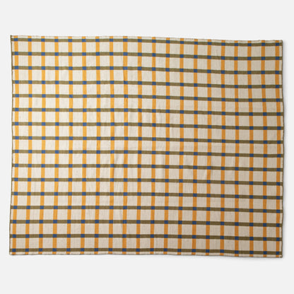 Overhead view of Plaid Wool Reversible Rug showcasing high-contrast yellow, olive, and blue plaid, handwoven from natural-dyed wool on a white studio background