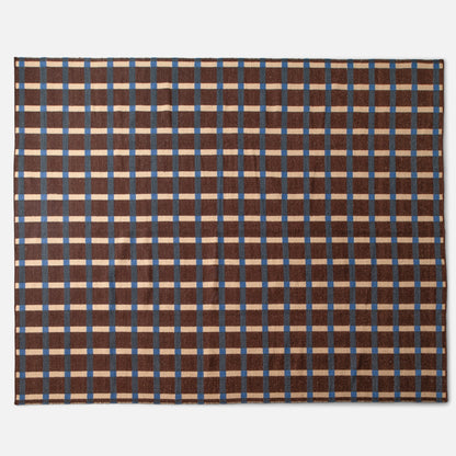 Top-down view of Plaid Wool Reversible Rug showcasing brown, blue, and cream high-contrast plaid and handwoven wool texture on a white background