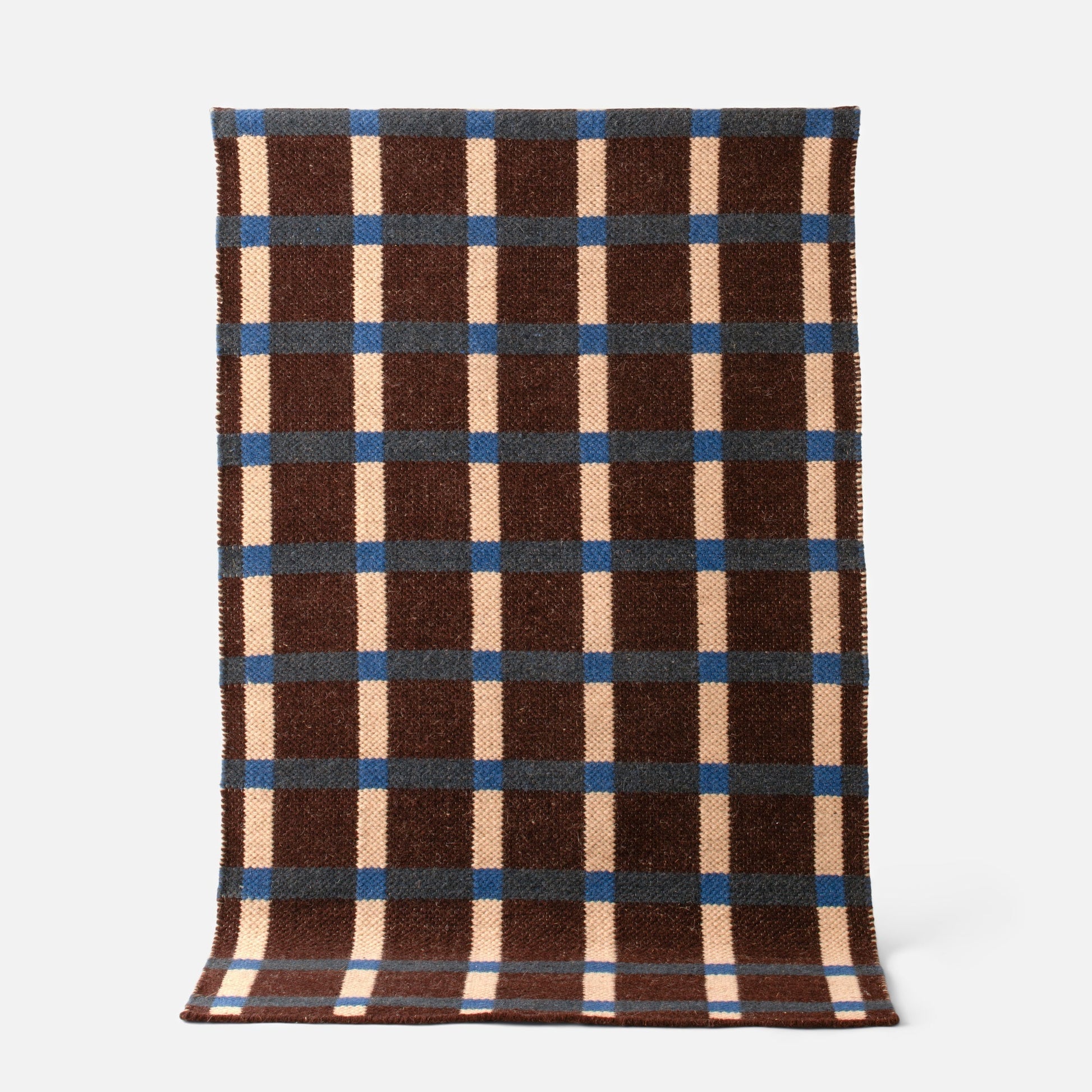 Top view of Plaid Wool Reversible Rug showcasing brown, cream, and blue plaid handwoven wool texture on a light background