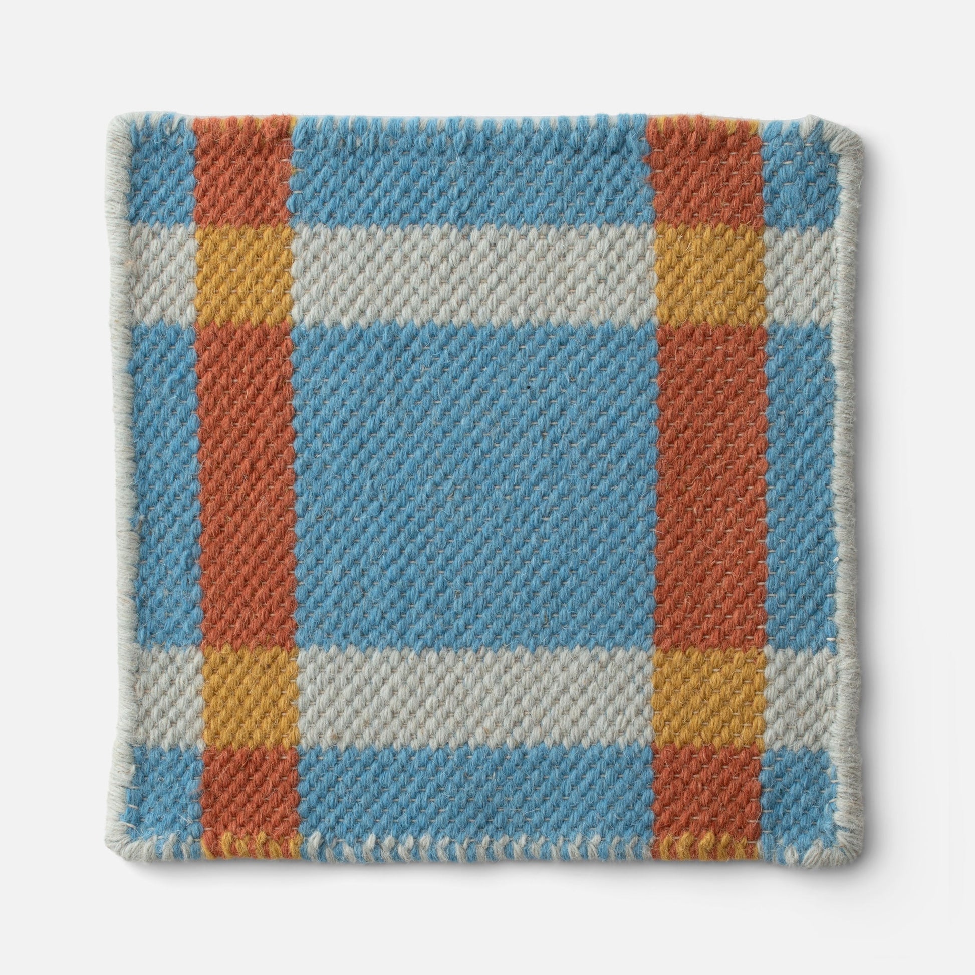 Close-up of Plaid Wool Reversible Rug showing woven wool texture, stitched edge, and blue, rust, mustard plaid on white