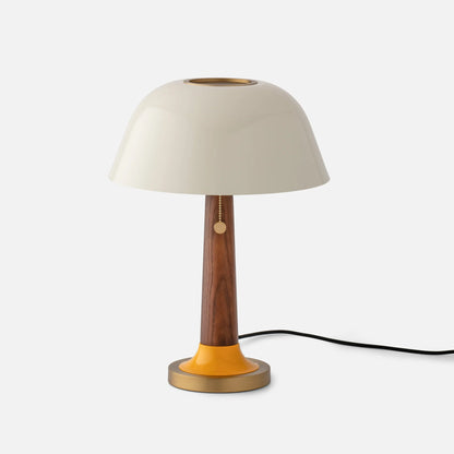 Front view of Evelyn Table Lamp showing white gloss mushroom shade, walnut wood stem, brass perforated diffuser, and yellow accent on white background