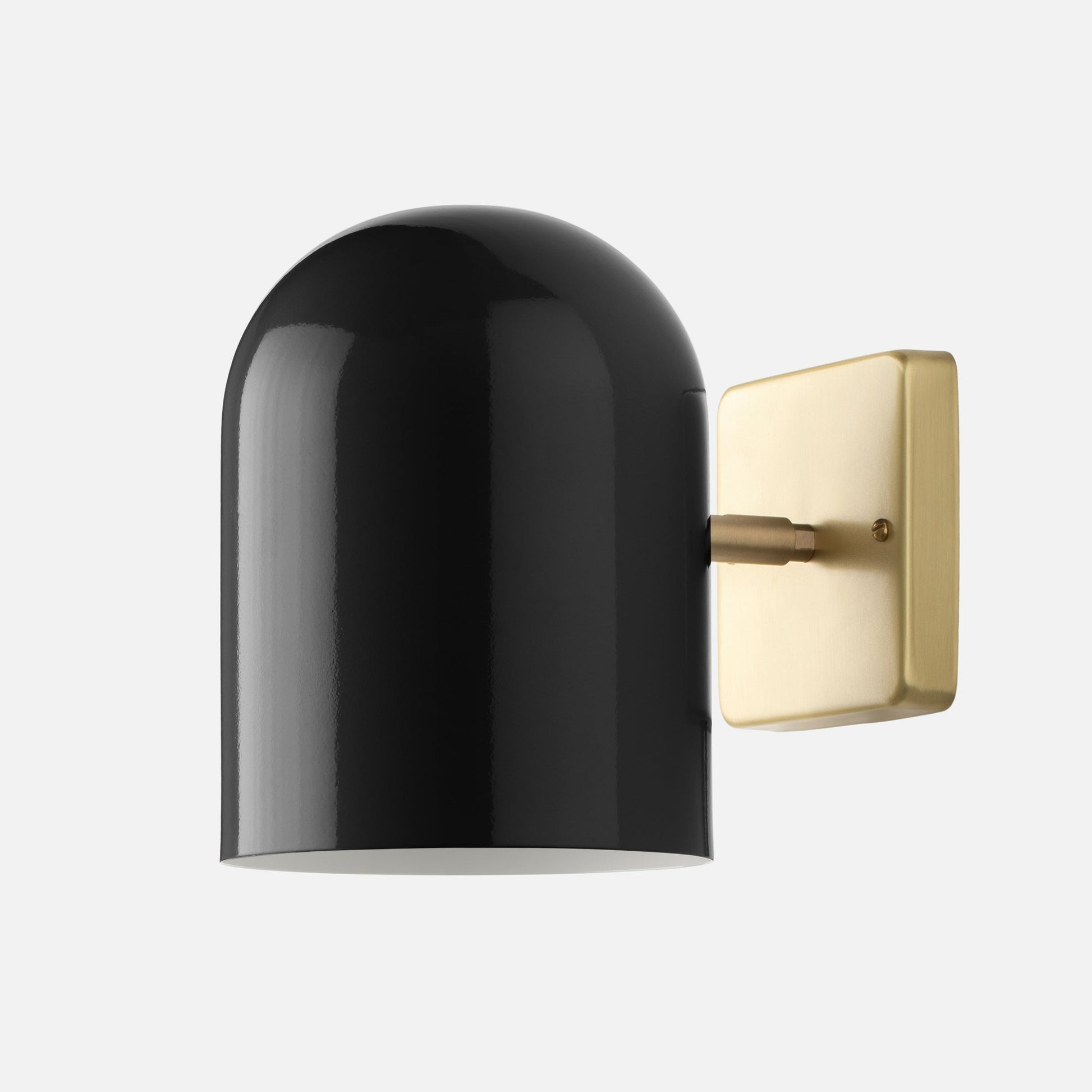 Side view of Allegheny Wall Sconce showcasing black gloss capsule shade and natural brass square backplate on light gray background