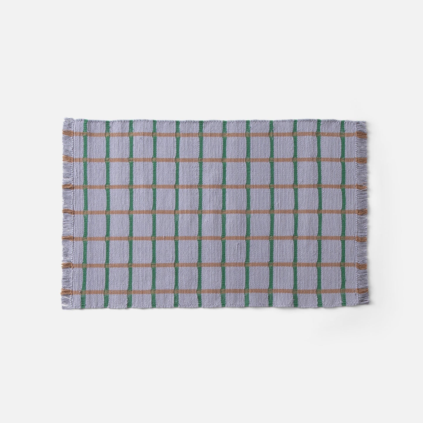Top edge of Cotton Grid Flatweave Rug in lavender with green vertical and tan horizontal grid lines and fringed edge on white background