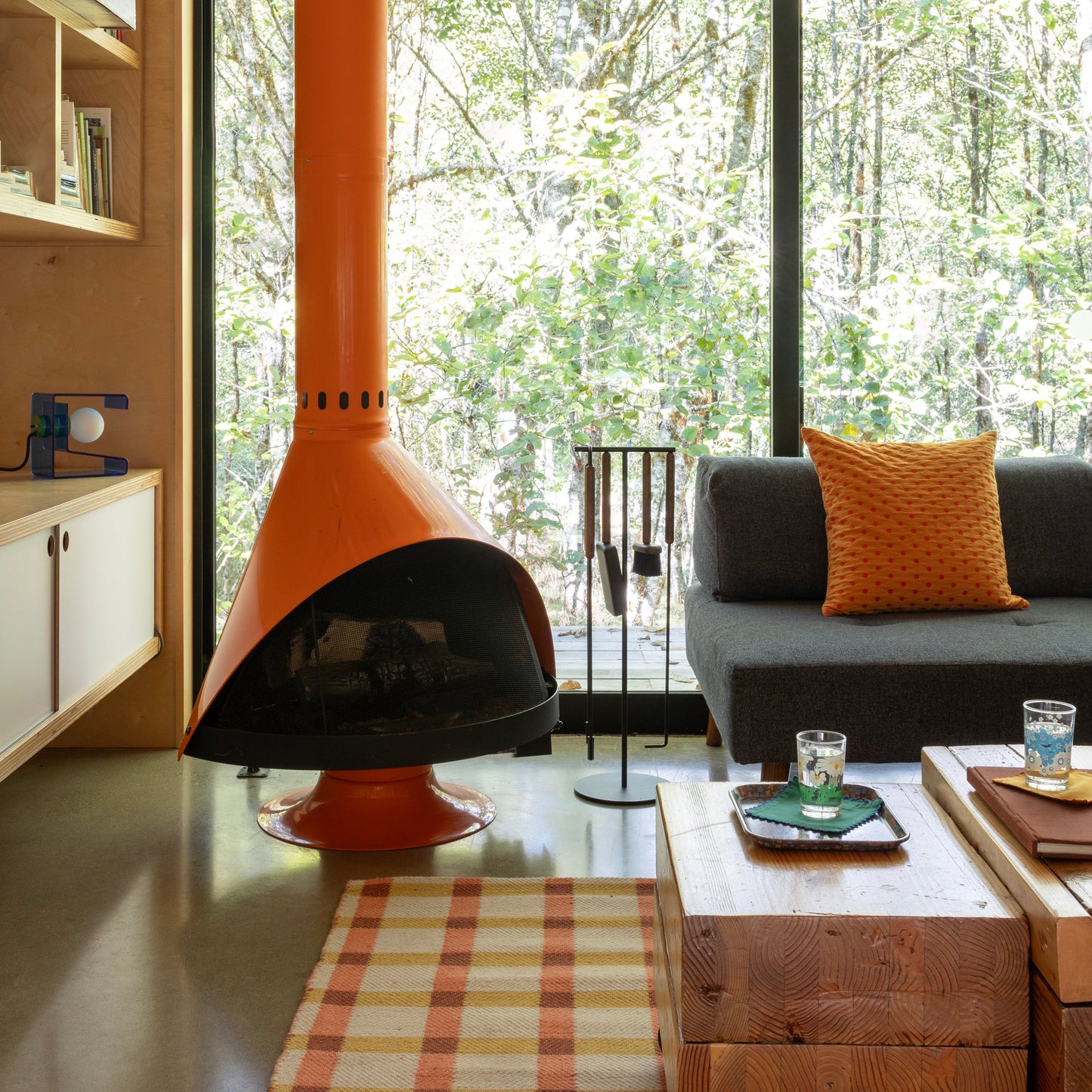 Plaid Wool Reversible Rug on floor in a cozy living room with orange cone fireplace and gray sofa