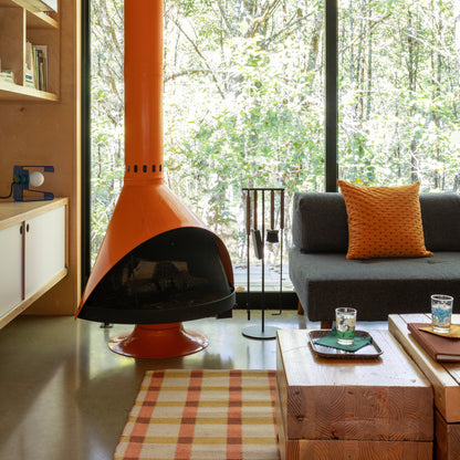 Plaid Wool Reversible Rug on floor in a cozy living room with orange cone fireplace and gray sofa