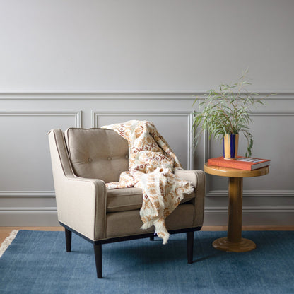 Armchair and side table on a blue Mesa wool rug in a cozy living room setting