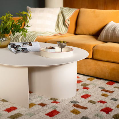 Coffee table with tray and magazine in front of a mustard sofa on Pixel Handloom Shag Rug showing a multicolored geometric pattern