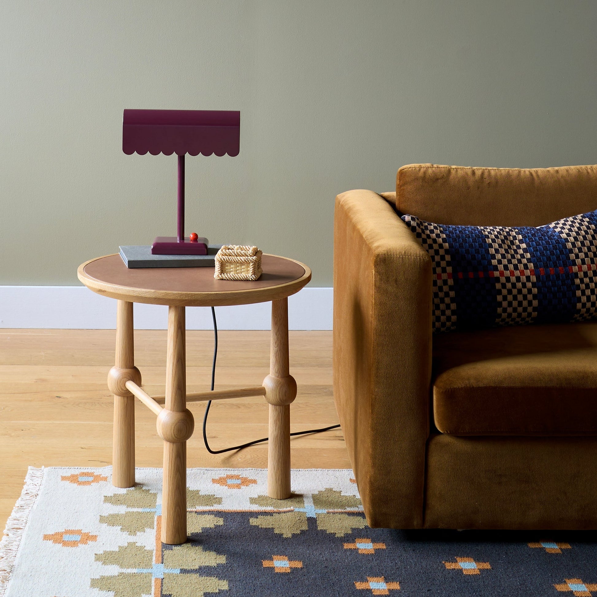 Flora Wool Flatweave Rug partially visible under a round oak side table beside a mustard sofa in a styled living room