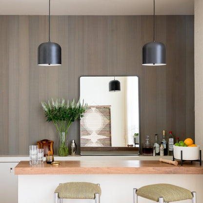 Rectangular Leo mirror reflecting a pendant light above a wooden countertop, with glassware, a vase of flowers, and a bowl of fruit
