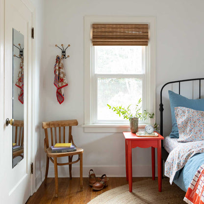 Wallowa Floral percale pillowcases styled on a bed with a blue accent pillow, red nightstand, and sunlit window in a cozy bedroom