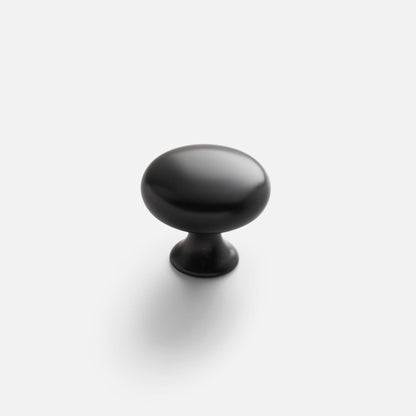 Angled view of Somerset large round knob showcasing smooth matte black finish on white background with soft shadow