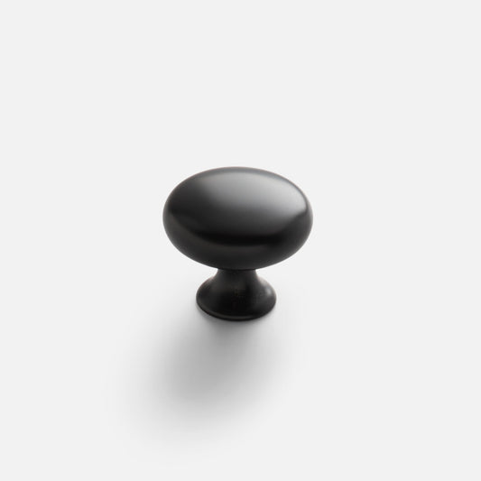 Angled view of Somerset large round knob showcasing smooth matte black finish on white background with soft shadow