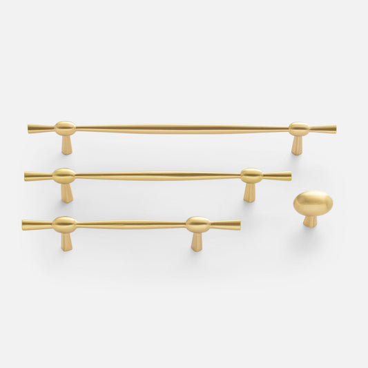 Top view of Eleanor hardware showing three brass pulls and one round brass knob in polished brass on white background
