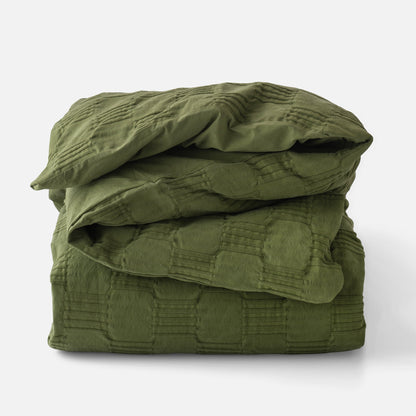 Folded view of Woven Tally Duvet Cover showing stitched grid texture in alder green on white background