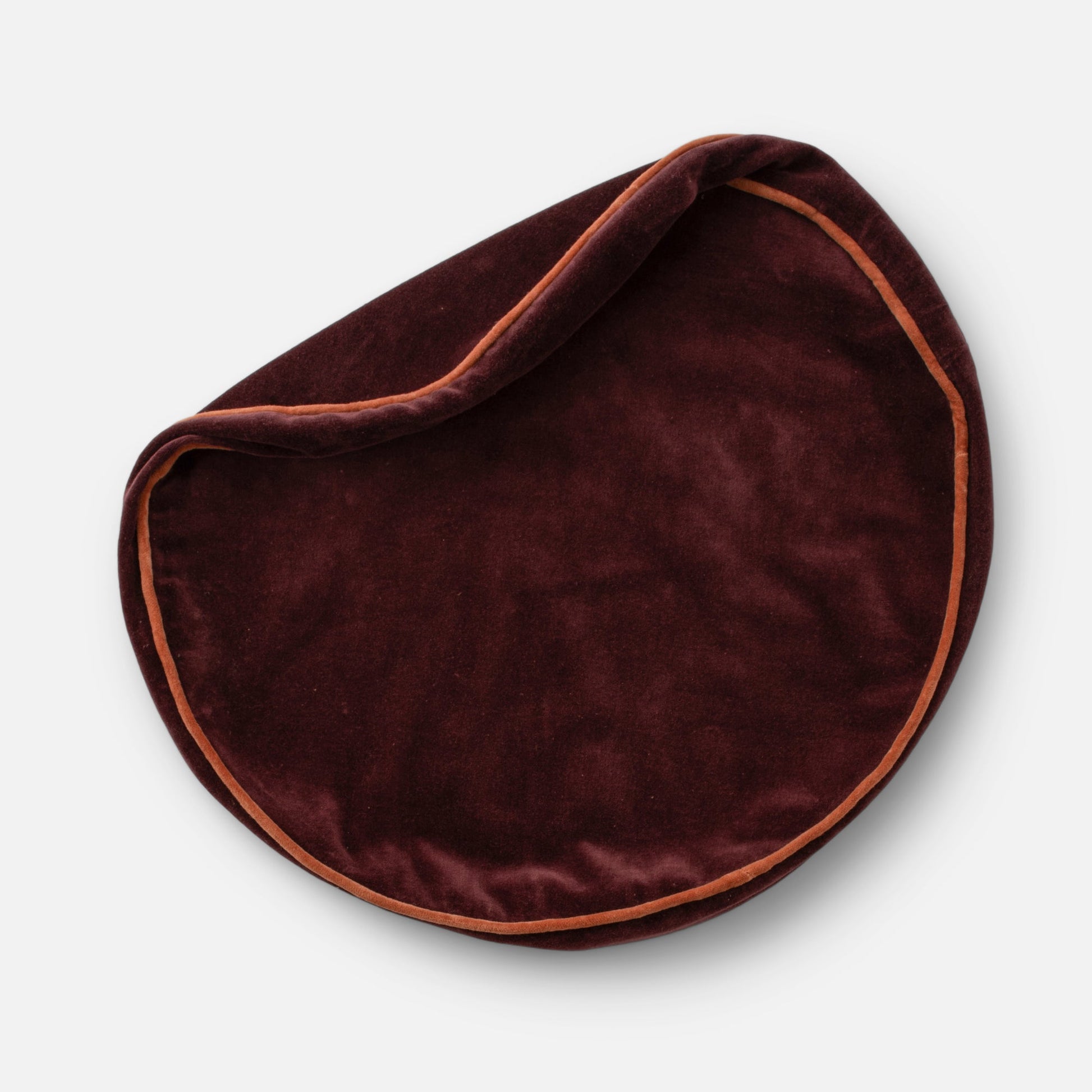 Overhead view of Velvet Piped Pillow showcasing raisin 100% cotton velvet with rust contrast piping on light gray background